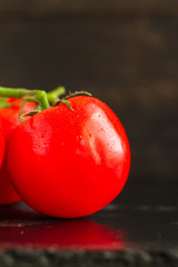 tomato on the green branch (red, ripe vegetable). food background. top view