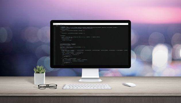 Concept of programming on a computer. Work desk with computer display and text editor.