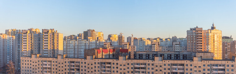 Wide panorama view of residential high-rise buildings, in the evening at sunset.