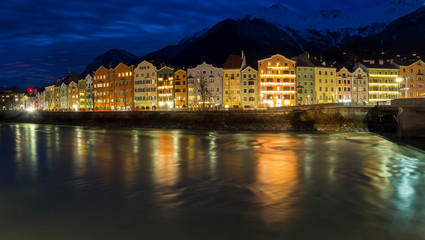 Fototapeta na wymiar Paisaje al anochecer en Innsbruck, Austria, con reflejos de las casas de colores en el agua a velocidad de disparo lenta. Diciembre 2018