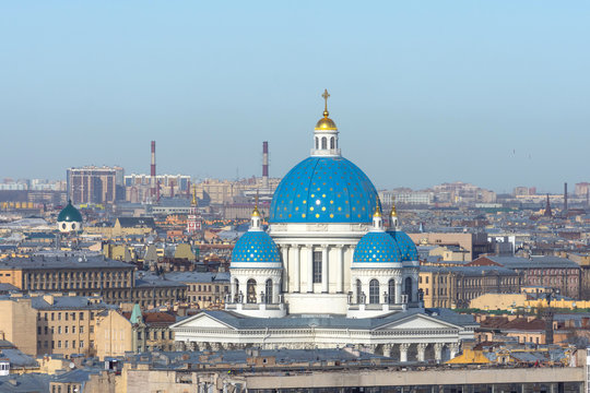 Trinity Cathedral with a blue dome and gold stars on the background of roofs in the city of St. Petersburg.