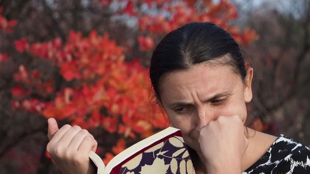 The girl of European appearance conducts an orchestra of trees and leaves of the autumn forest Girl of the European appearance stands face to the autumn forest in the headphones and conducting the orc