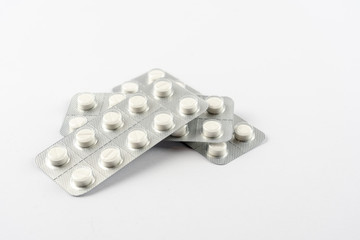 Strips with white pills in blister pack isolated on a white back ground