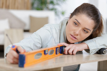 handywoman using a measuring level
