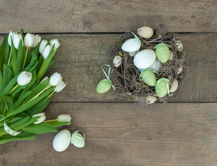 Osternest und Tulpenstrauß auf Holzhintergrund, Dekoration zu Ostern