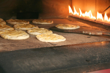 Inside of oven fireplace and breads in it, at a bakery