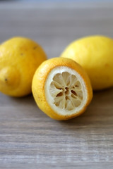 Raw organic lemons on a wooden table. Selective focus.