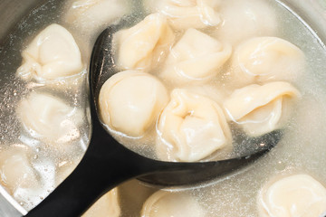 Dumpling ravioli on a strainer for filtering from water and laying on the table for eating