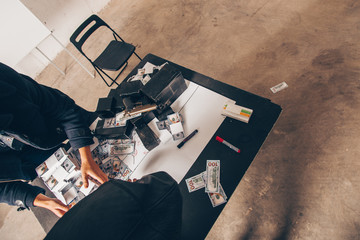 Men in black counting money from robbery