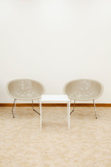 two beige chairs and white coffee table