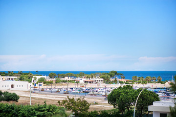 Beautiful drone view of harbor and beach side. Houses and buildings with solar panels built next to ocean or sea. Luxury lifestyle. Concept of travelling and summer holidays