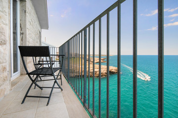 Fototapeta na wymiar Braided modern garden furniture set on a sea side cliff balcony with a view of the horizon. 
