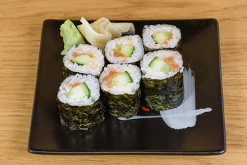 sushi roll of cucumbers and umekyu served on a black plate