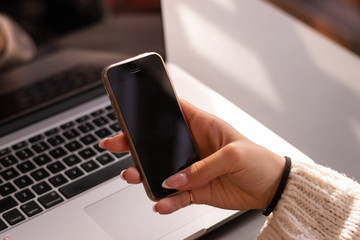 Cropped image of female holding smartphone getting message with confirmation making transaction on...