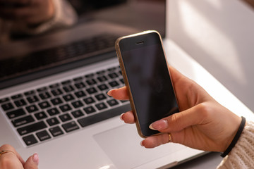 Cropped image of female holding smartphone getting message with confirmation making transaction on...