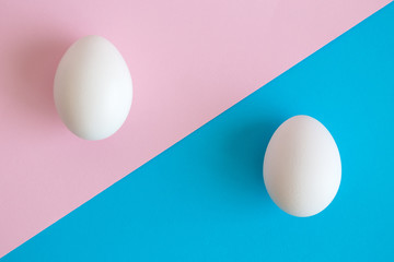 White Easter eggs on pastel background. Happy Easter minimal concept. Flat lay. Top view.