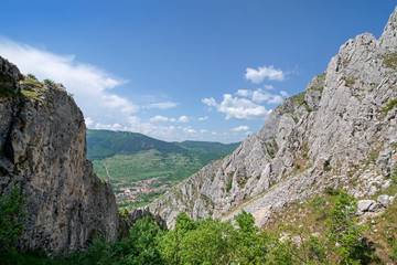 Sunny summer day at mountain peak, where tourists climb to conquer fear, find courage and develop lateral thinking skills to overcome difficulty of climbing a mountain. Small road with rolling stones 