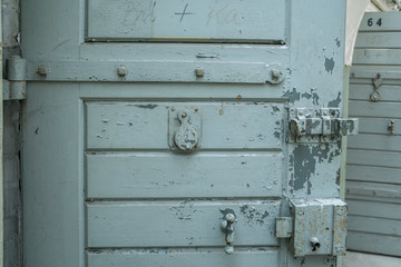 Close up of a peep hole in grunge metal the door of an old prison.