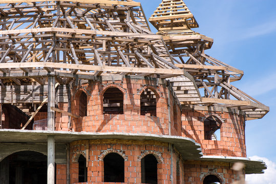 District for rich people with traditional, large gypsy house with luxury decorations and ornaments on the roof in Huedin, Romania. Houses being under construction. Concept of bankruptcy, and abandoned