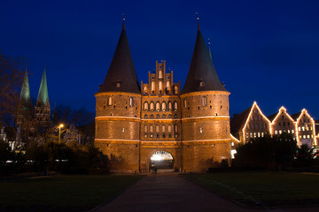 Fototapeta premium Holstentor bei Nacht beleuchtet