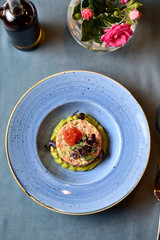 salmon tartare with red caviar on a blue plate