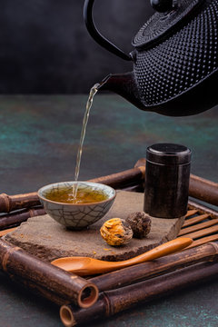 Green tea pouring into traditional oriental cup