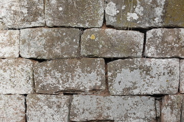 Alte Trockenmauer, Mauer aus Stein mit Löchern, Rissen, Moos und Fugen als Close up