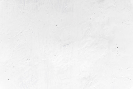 Adobe whitewashed wall in natural white color, traces of brush, texture and background