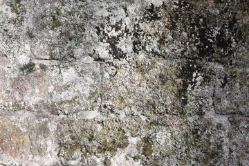 Hintergrundbild einer alten grauen Mauer aus Stein mit vielen Spalten, Rissen und Fugen 