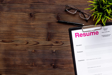 Review resumes of applicants set with glasses wooden work desk background top view mockup