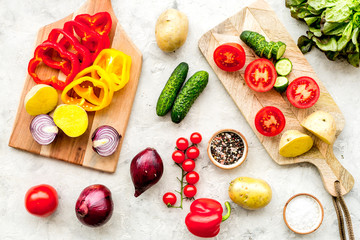 Fresh food ingredients for vegetarian kitchen on white stone background top view