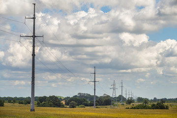 Power line in the field at cloudy summer day