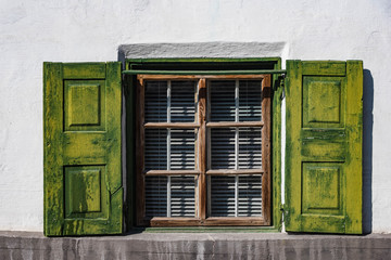 Holzkastenfenster mit grünen Fensterläden