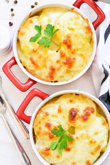 Potato casserole with bechemel sauce and cheese on the kitchen table. Top view.