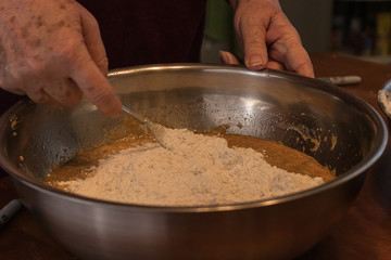 Fototapeta premium adding and mixing in flour into a bowl