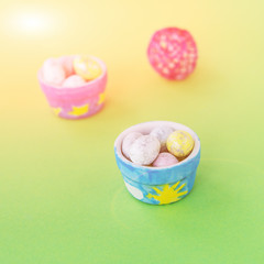 Easter painted eggs in ceramic dishes on the green background