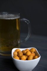 Photo of a glass of beer with nuts. Light beer on a dark background. Beer banner design