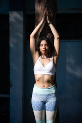 Beautiful young woman does yoga in the nature.