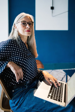Senior businesswoman working on laptop at office.