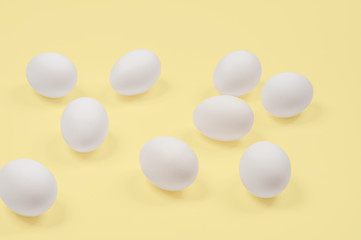 White egg. Raw eggs on pastel yellow background.