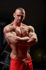 Fototapeta na wymiar Athletic man posing. Photo of man with perfect physique on black background. Strength and motivation