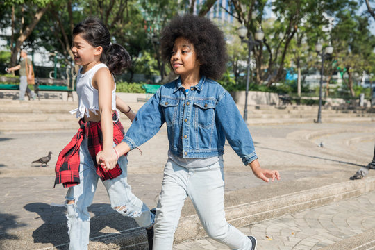 Two girls holding hands and walking