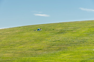 A woman rests on the grass slope to Almhöjden at Skogskyrkogården in Stockholm