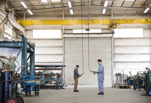 Male factory wokers using electric lift