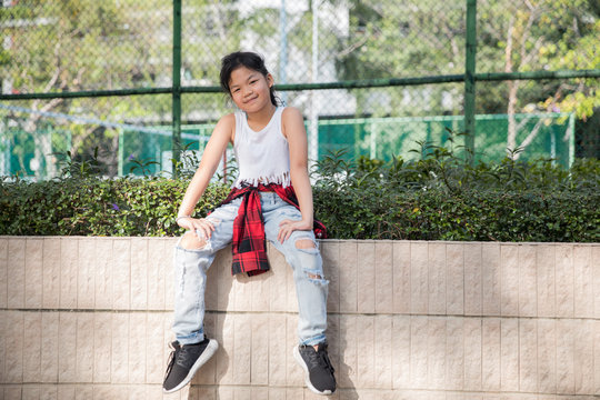Portrait of a cute girl sitting alone in the park