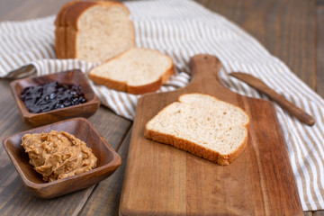 Obraz na płótnie Canvas Peanut Butter, Grape Jelly, Loaf Bread Gathered to Make Sandwiches