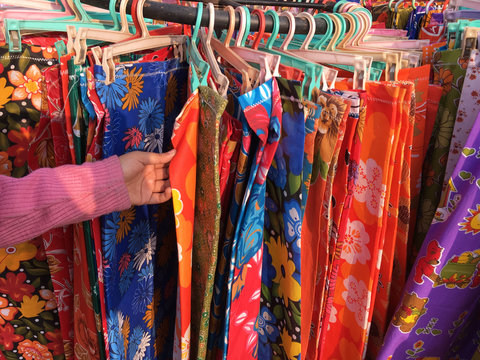 A girl selecting colorful cloths in a market