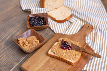 Obraz na płótnie Canvas Peanut Butter, Grape Jelly, Loaf Bread Gathered to Make Sandwiches