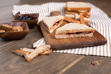 Peanut Butter and Jelly Sandwich on Cutting Board on Wooden Table