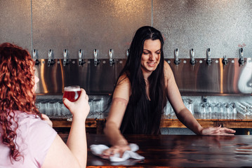 Female bartender cleaning the bar at a craft beer brewery